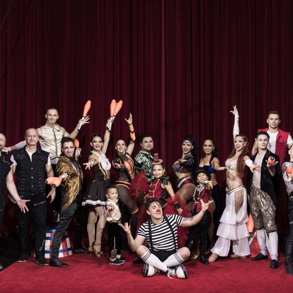 a group of people posing in front of a curtain